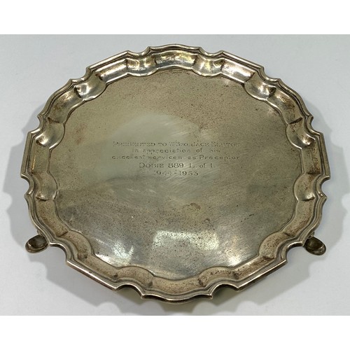 134 - A silver salver with shaped rim, inscription to centre, raised on three pad feet, Sheffield, 1930, m... 