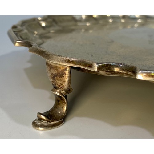 134 - A silver salver with shaped rim, inscription to centre, raised on three pad feet, Sheffield, 1930, m... 