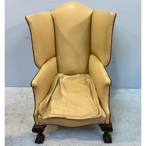 618 - A large Victorian wingback armchair upholstered in cream leather with studding to top, sides and bac... 