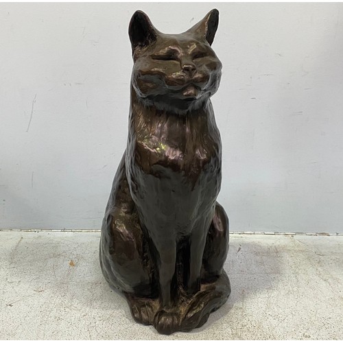 570 - A modern cold cast copper seated black cat with tail curled around its feet by Peter Close, incised ... 