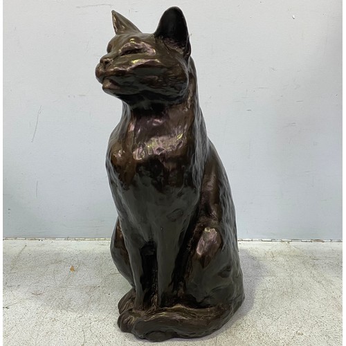 570 - A modern cold cast copper seated black cat with tail curled around its feet by Peter Close, incised ... 