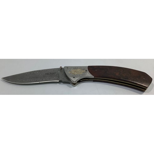 517 - A South African folding knife by John Wilmot with silver inlaid Damascus blade and wooden handle, bl... 