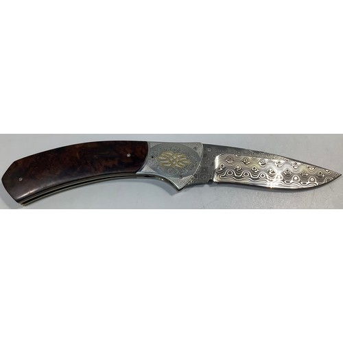 517 - A South African folding knife by John Wilmot with silver inlaid Damascus blade and wooden handle, bl... 