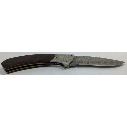 517 - A South African folding knife by John Wilmot with silver inlaid Damascus blade and wooden handle, bl... 