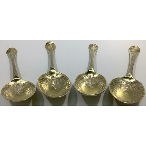 155 - A matched set of four mid-18th century silver bright-cut and later gilded berry spoons, various make... 