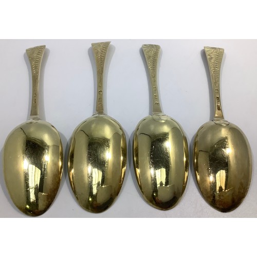 155 - A matched set of four mid-18th century silver bright-cut and later gilded berry spoons, various make... 