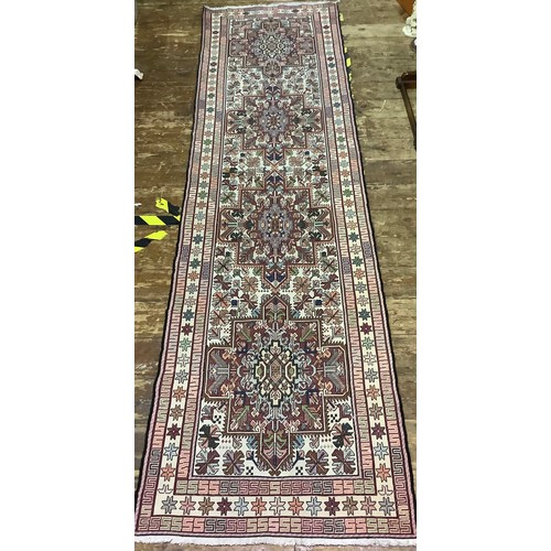 588 - A long woollen hand-knotted runner with geometric designs to cream ground, 300 x 83cm