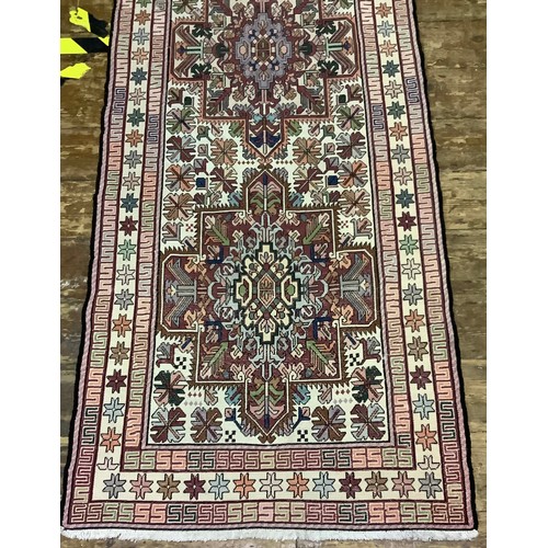 588 - A long woollen hand-knotted runner with geometric designs to cream ground, 300 x 83cm