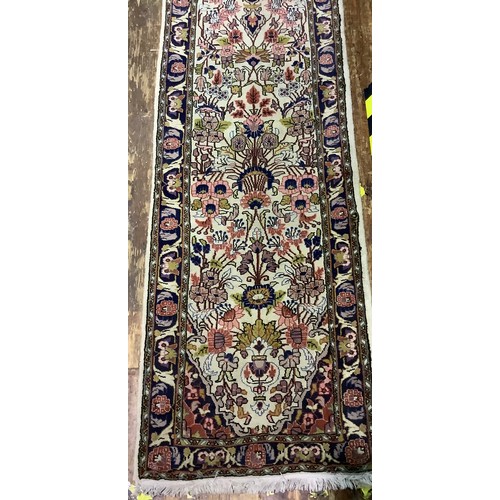 587 - A long woollen hand-knotted runner decorated with flowers to cream ground, 360 x 65cm