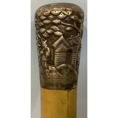 392 - A white metal (tests as silver) topped walking stick, pommel decorated with continuous moulded relie... 