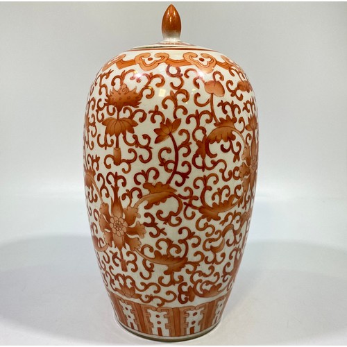 100 - A Chinese porcelain ginger jar and cover of elongated ovoid form, decorated all-over in iron red flo... 