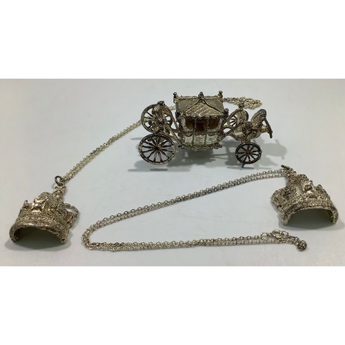165 - A cast silver model of the British Coronation Carriage and two silver crown pendants on chains, all ... 