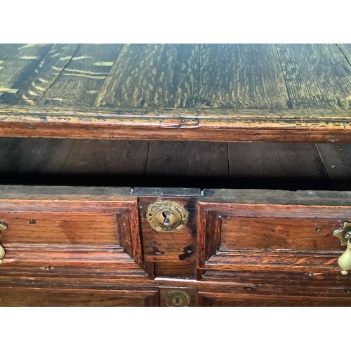 633 - A 17th century oak chest of four long, graduated drawers with panelled fronts, brass drop pulls and ... 