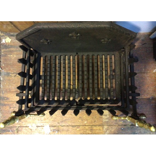 398 - A cast iron and brass fire grate, with pierced sides and bottom and solid raised back with fleur-de-... 