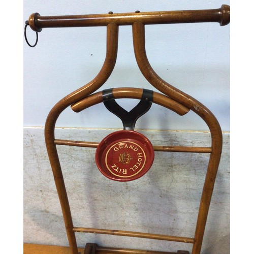 609 - A mahogany clothes/suit stand, with metal suspension rings to each side of top rail, above a metal m... 