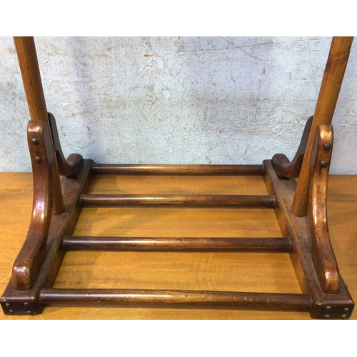 609 - A mahogany clothes/suit stand, with metal suspension rings to each side of top rail, above a metal m... 