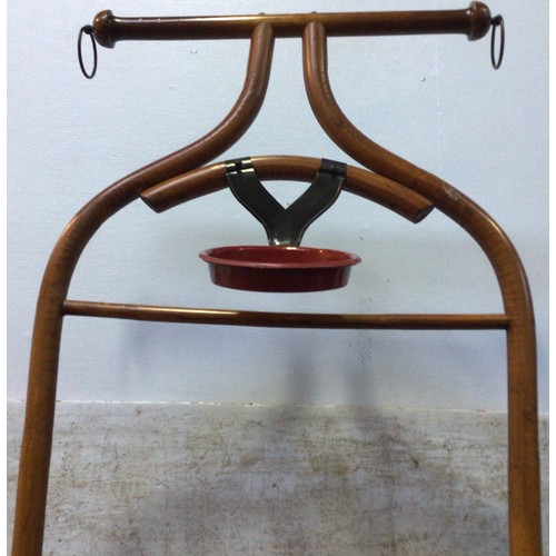 609 - A mahogany clothes/suit stand, with metal suspension rings to each side of top rail, above a metal m... 