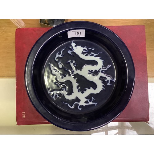 101 - A Chinese porcelain 'scarificial blue' dragon dish, with white reserved dragon to richly applied dee... 