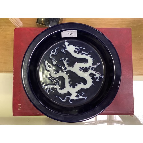 101 - A Chinese porcelain 'scarificial blue' dragon dish, with white reserved dragon to richly applied dee... 