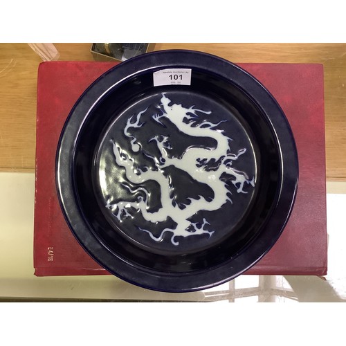 101 - A Chinese porcelain 'scarificial blue' dragon dish, with white reserved dragon to richly applied dee... 