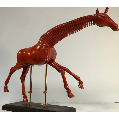 467 - An artist’s giraffe lay model or sculpture, red stained wood, on black wooden base with fully articu... 