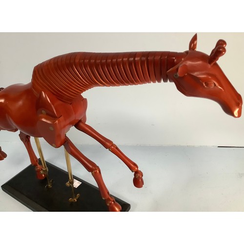 467 - An artist’s giraffe lay model or sculpture, red stained wood, on black wooden base with fully articu... 