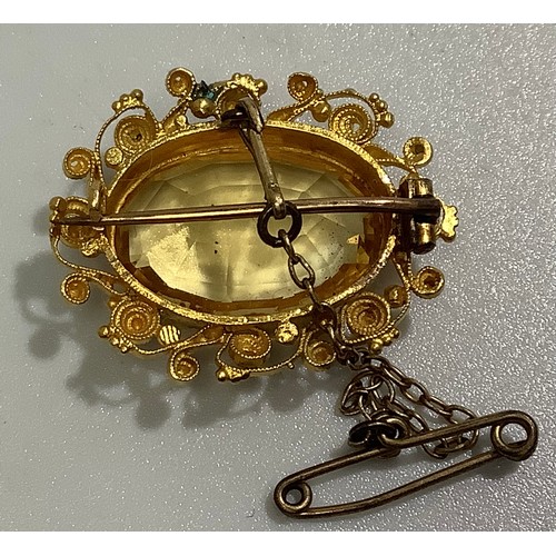 198 - An antique high carat gold, probably 18ct, filigree brooch, centrally claw set with a large, faceted... 