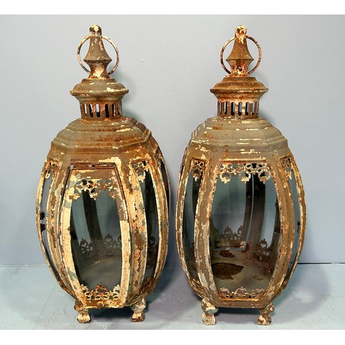 405 - A pair of cream painted wrought iron and glass panel hanging garden lanterns of swelled octagonal fo... 