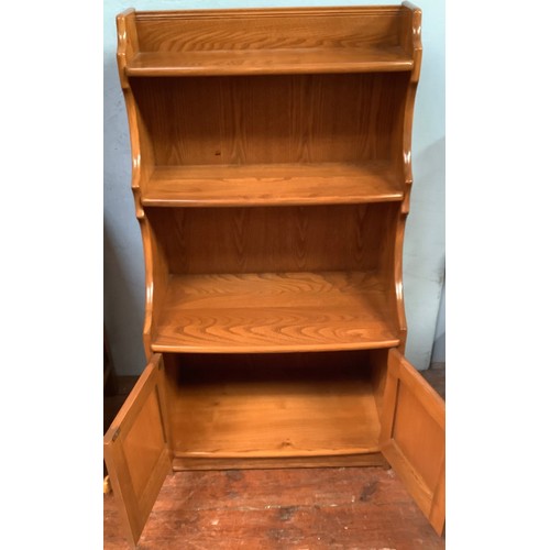 514 - An Ercol Golden Dawn 'Crendance Cupboard'  and matching 'Waterfall Bookcase' together with an oak tw... 