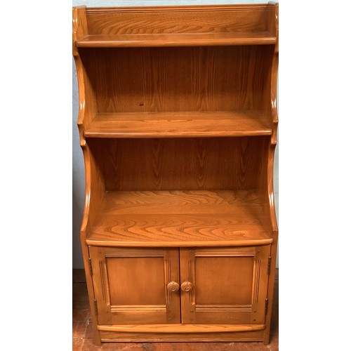 514 - An Ercol Golden Dawn 'Crendance Cupboard'  and matching 'Waterfall Bookcase' together with an oak tw... 