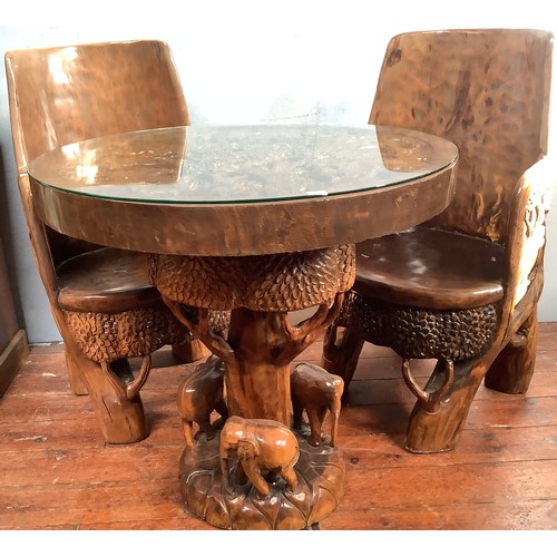 515 - An African carved solid wooden table and four chairs, probably Acacia wood, the solid chairs and tab... 