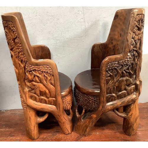 515 - An African carved solid wooden table and four chairs, probably Acacia wood, the solid chairs and tab... 