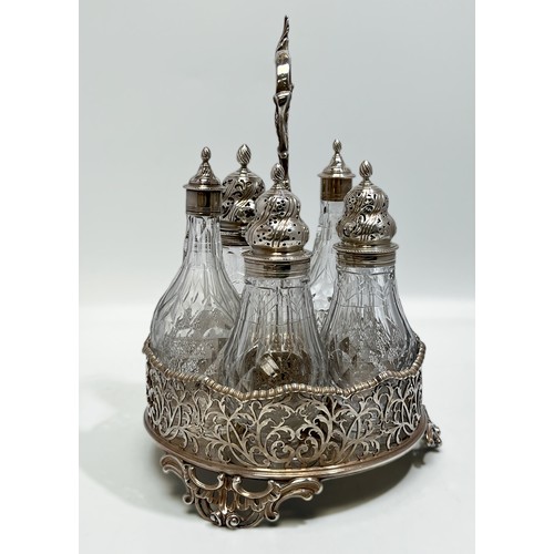 93 - A George III Silver 5-bottle cruet stand, with scrolling foliate handle and feet, gadrooned wavey ri... 