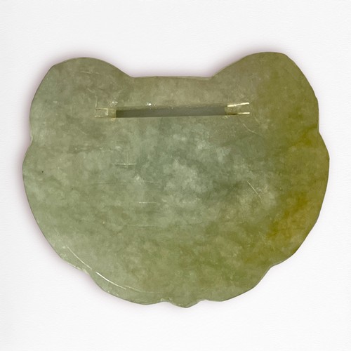 67 - A russet-tinged celedon jade Lingzhi spirit-lock plaque, each side lightly line-carved with characte... 