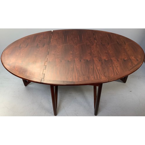 423 - A mid-century rosewood oval drop leaf dining table, the top with square sectioned piano hinges to ea... 