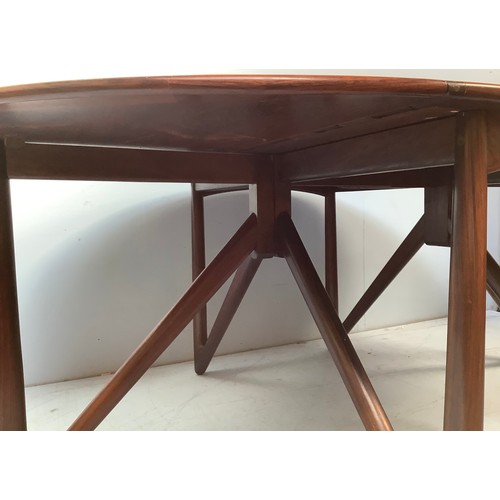 423 - A mid-century rosewood oval drop leaf dining table, the top with square sectioned piano hinges to ea... 