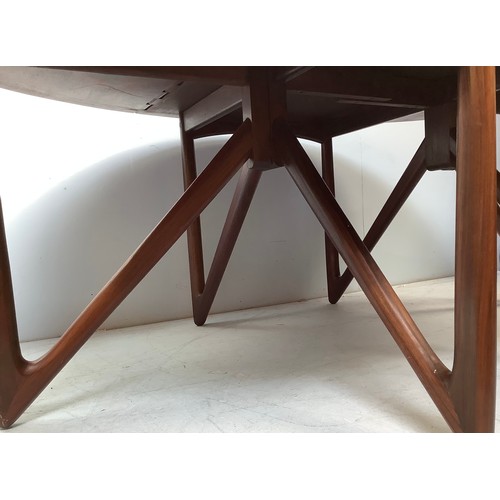 423 - A mid-century rosewood oval drop leaf dining table, the top with square sectioned piano hinges to ea... 