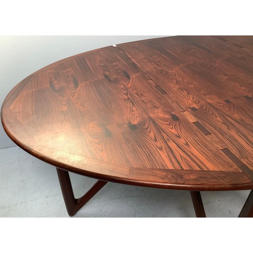 423 - A mid-century rosewood oval drop leaf dining table, the top with square sectioned piano hinges to ea... 