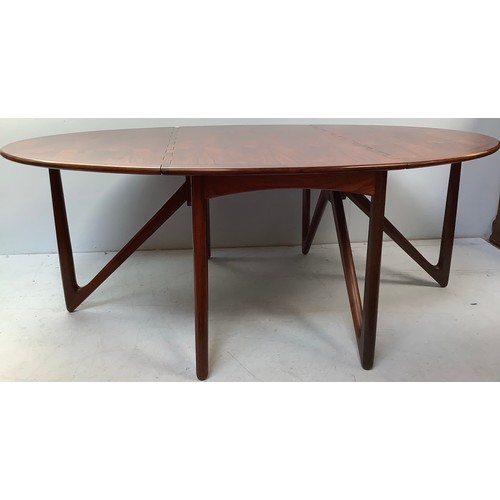 423 - A mid-century rosewood oval drop leaf dining table, the top with square sectioned piano hinges to ea... 