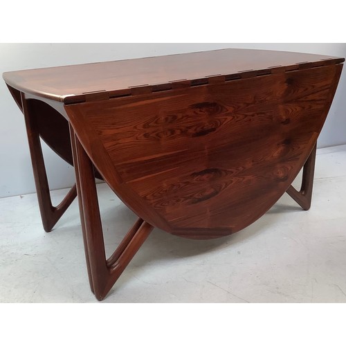 423 - A mid-century rosewood oval drop leaf dining table, the top with square sectioned piano hinges to ea... 