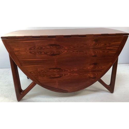 423 - A mid-century rosewood oval drop leaf dining table, the top with square sectioned piano hinges to ea... 