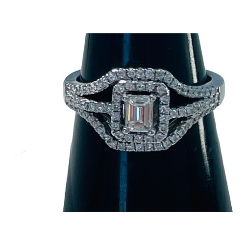 192 - An 18ct white gold diamond ring, set with a central emerald cut diamond, measuring 5mm x 6mm, surrou... 