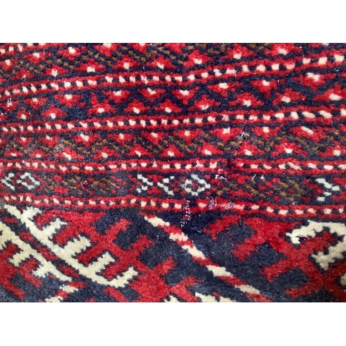 406 - A hand-knotted wool Bokhara Rug, worked with a field of stylised guls to a red ground, within a bord... 