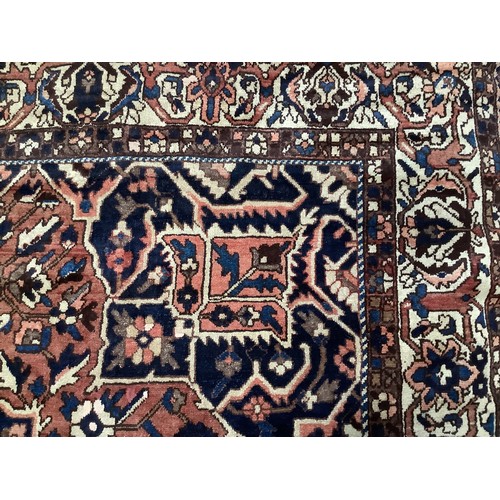 411 - A Persian Bakhtiar carpet, with stylised blue and red central medallion and blue spandrels, cream ou... 