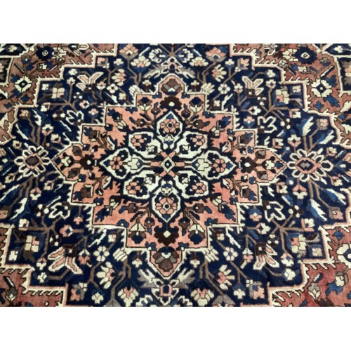 411 - A Persian Bakhtiar carpet, with stylised blue and red central medallion and blue spandrels, cream ou... 