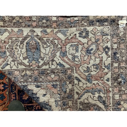 411 - A Persian Bakhtiar carpet, with stylised blue and red central medallion and blue spandrels, cream ou... 