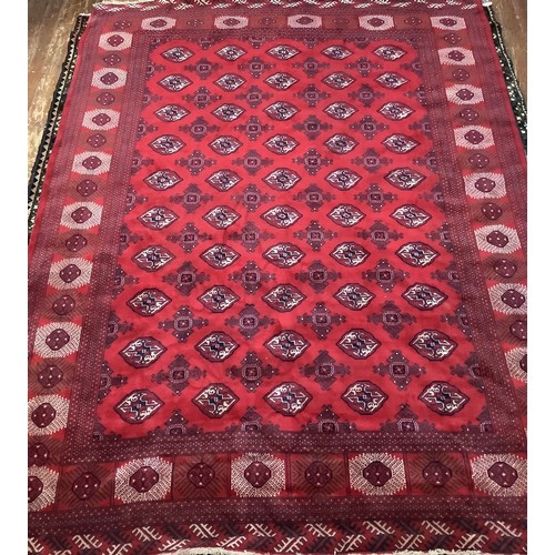 412 - A hand-knotted wool Bokhara carpet, worked with a field of stylised guls and herati to the red field... 