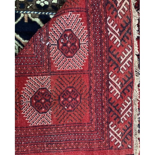 412 - A hand-knotted wool Bokhara carpet, worked with a field of stylised guls and herati to the red field... 