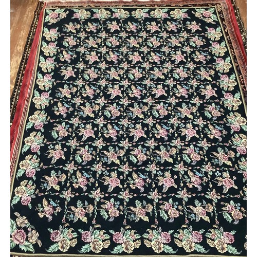 414 - A hand-knotted fatweave floral carpet, worked with a field of roses and trellis to a black ground wi... 