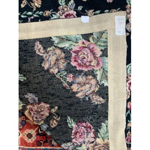 414 - A hand-knotted fatweave floral carpet, worked with a field of roses and trellis to a black ground wi... 